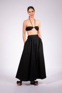 Model wearing the Solid Maxi Skirt front front color black made with 98% Cotton 2% Elastane, styled for resortwear look
