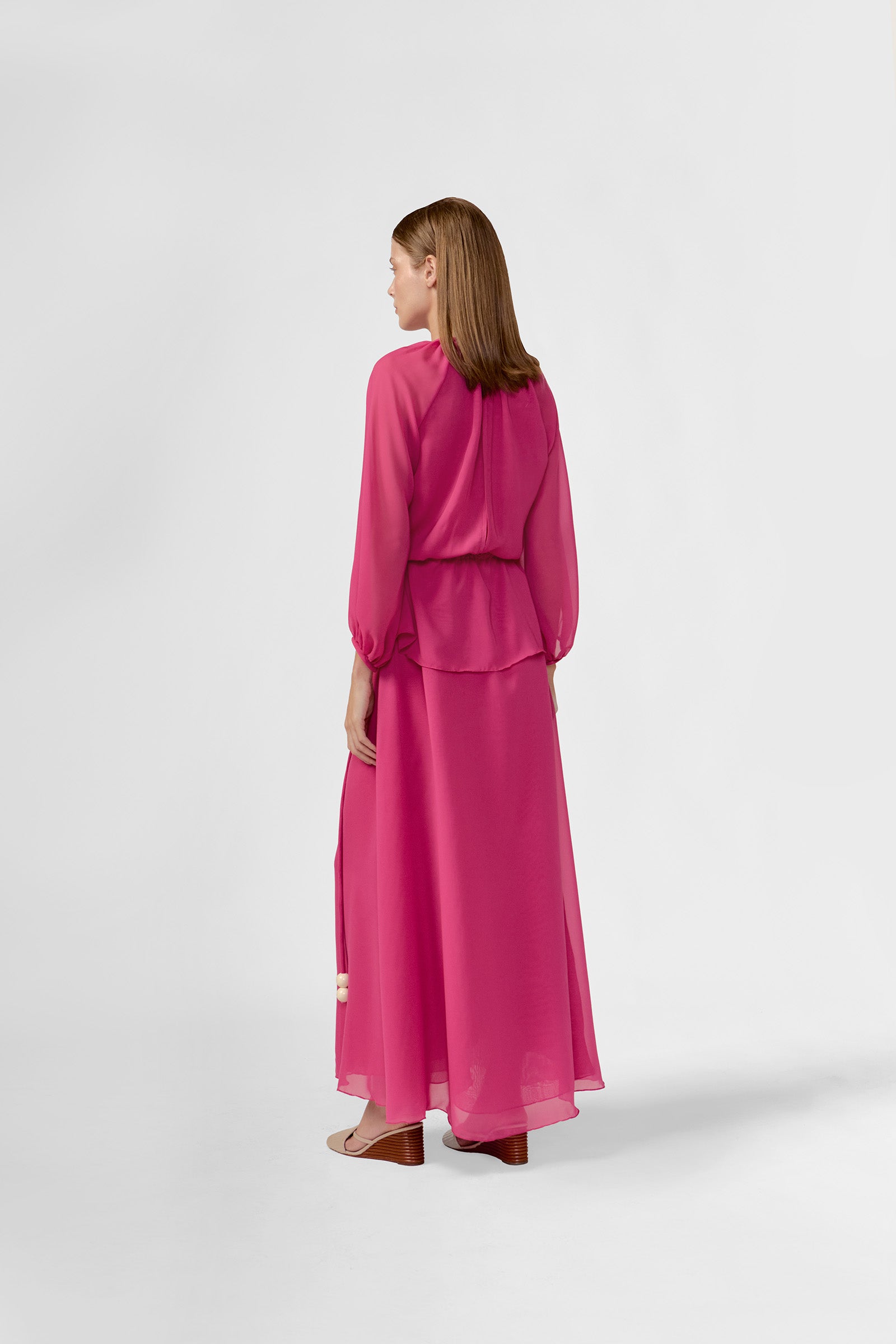 Model wearing the Solid Peplum Maxi Dress back color pink made with 100% Cotton, styled for resortwear look