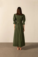 Model wearing the Solid Puff-Sleeved Long Dress back color dark green with 98% cotton and 2% elastane fabric styled for a resort look
