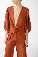 Model wearing the Solid Puff-Sleeved Shirt color coganac detail with 100% viscose fabric styled for a resort look