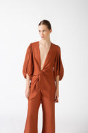 Model wearing the Solid Puff-Sleeved Shirt color coganac with 100% viscose fabric styled for a resort look