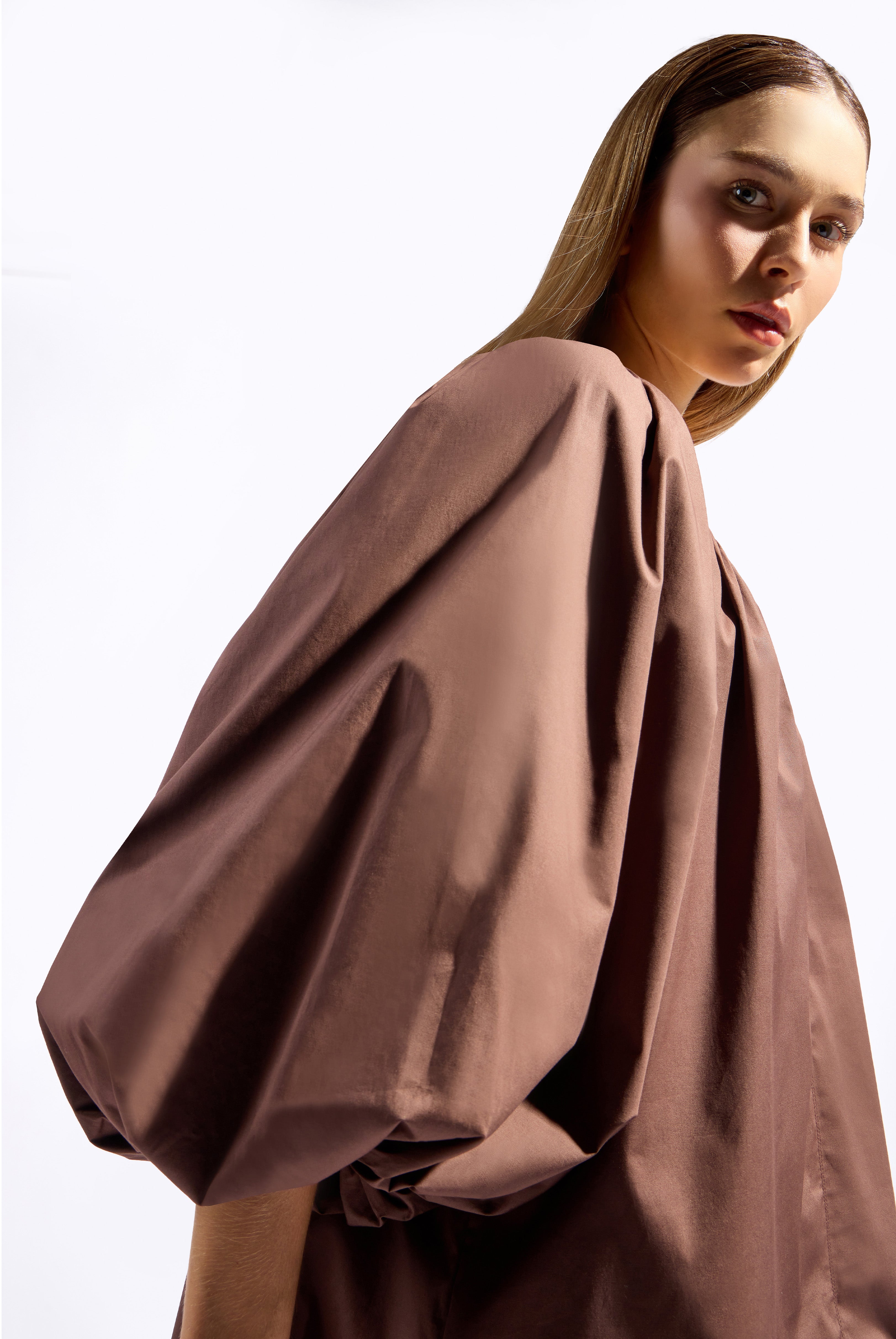 Model wearing the Solid Puff Sleeve Mini Dress detail color coffee made with 97% Cotton 3% Elastane,  styled for resortwear look 