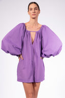 Model wearing the Solid Puff Sleeve Mini Dress front color purple made with 100% Cotton, styled for resortwear look 