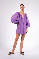 Model wearing the Solid Puff Sleeve Mini Dress look color purple made with 100% Cotton,  styled for resortwear look 