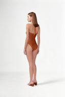 Model wearing the Solid Ruched Swimsuit back color cognac, made from 85% plyamide 15% elastane, styled for a beachwear look