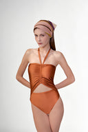 Model wearing the Solid Ruched Swimsuit detail color cognac, made from 85% plyamide 15% elastane, styled for a beachwear look