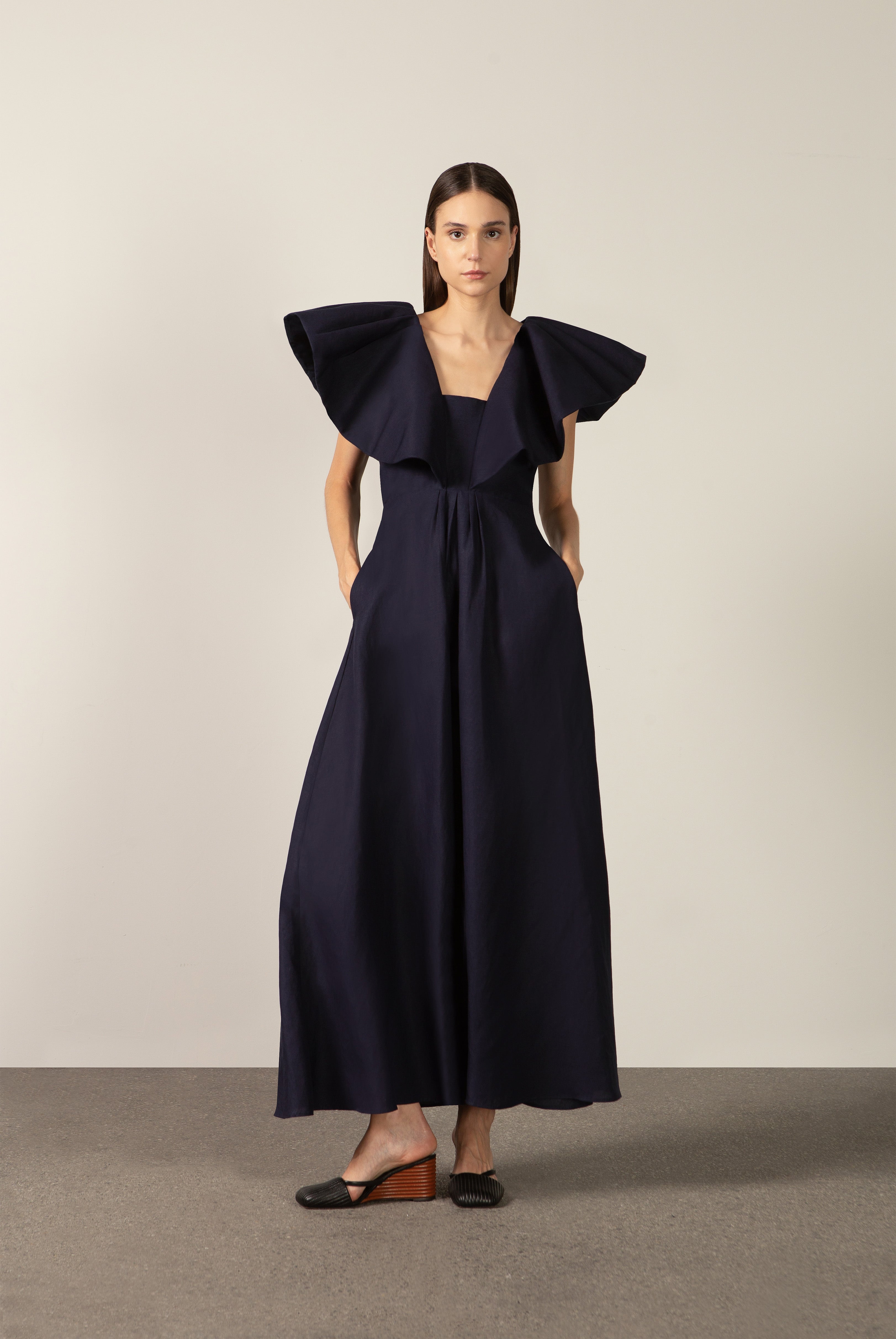 Model wearing the Solid Ruffled Maxi Dress front color navy made with 55% viscose 45% Linen, styled for resortwear look