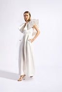 Model wearing the Solid Ruffled Maxi Dress front color off white made with 55% viscose 45% Linen, styled for resortwear look