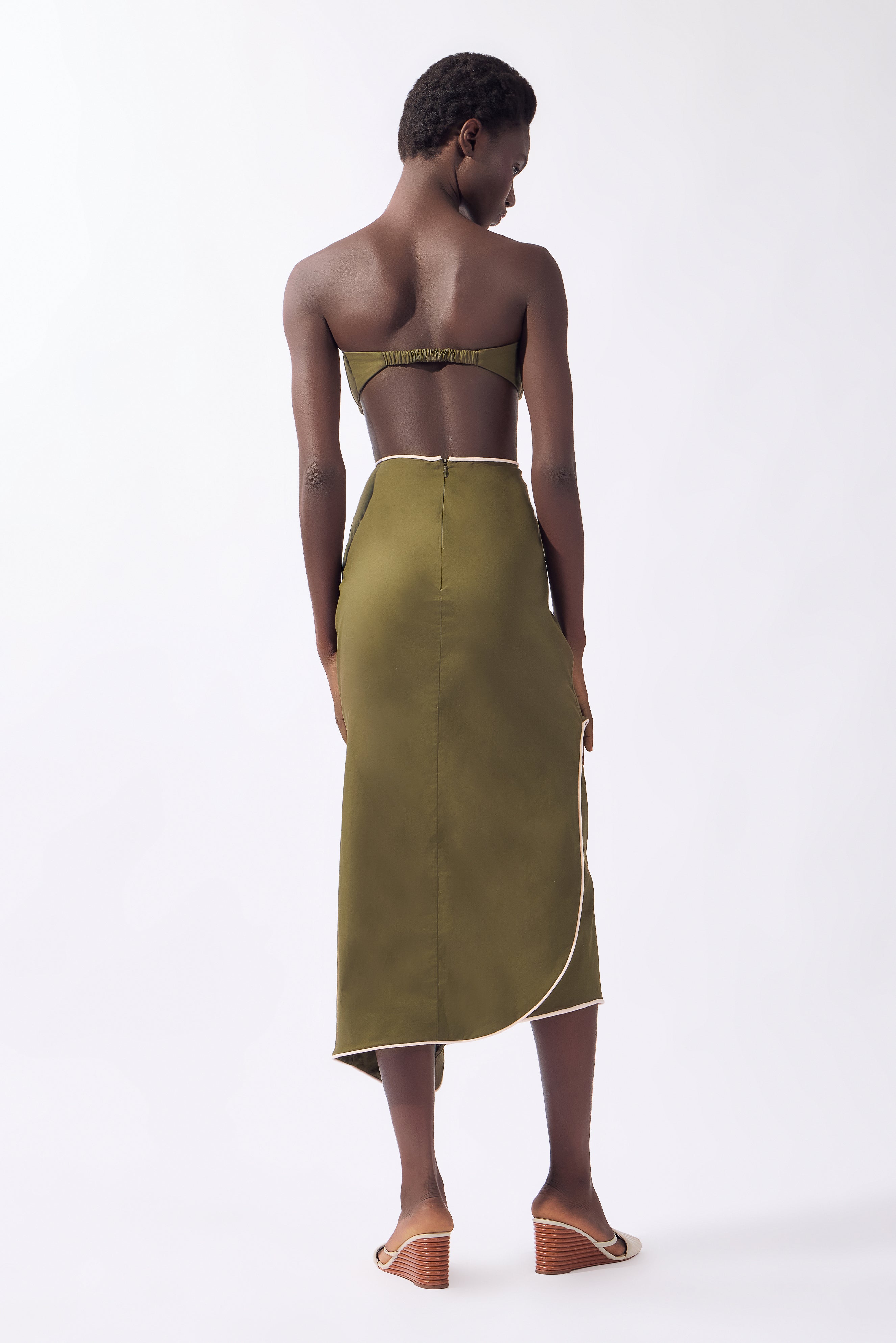Model wearing the Solid Ruffled Midi Skirt back, color green, made from 98% cotton 2% elastane, styled for a resort look