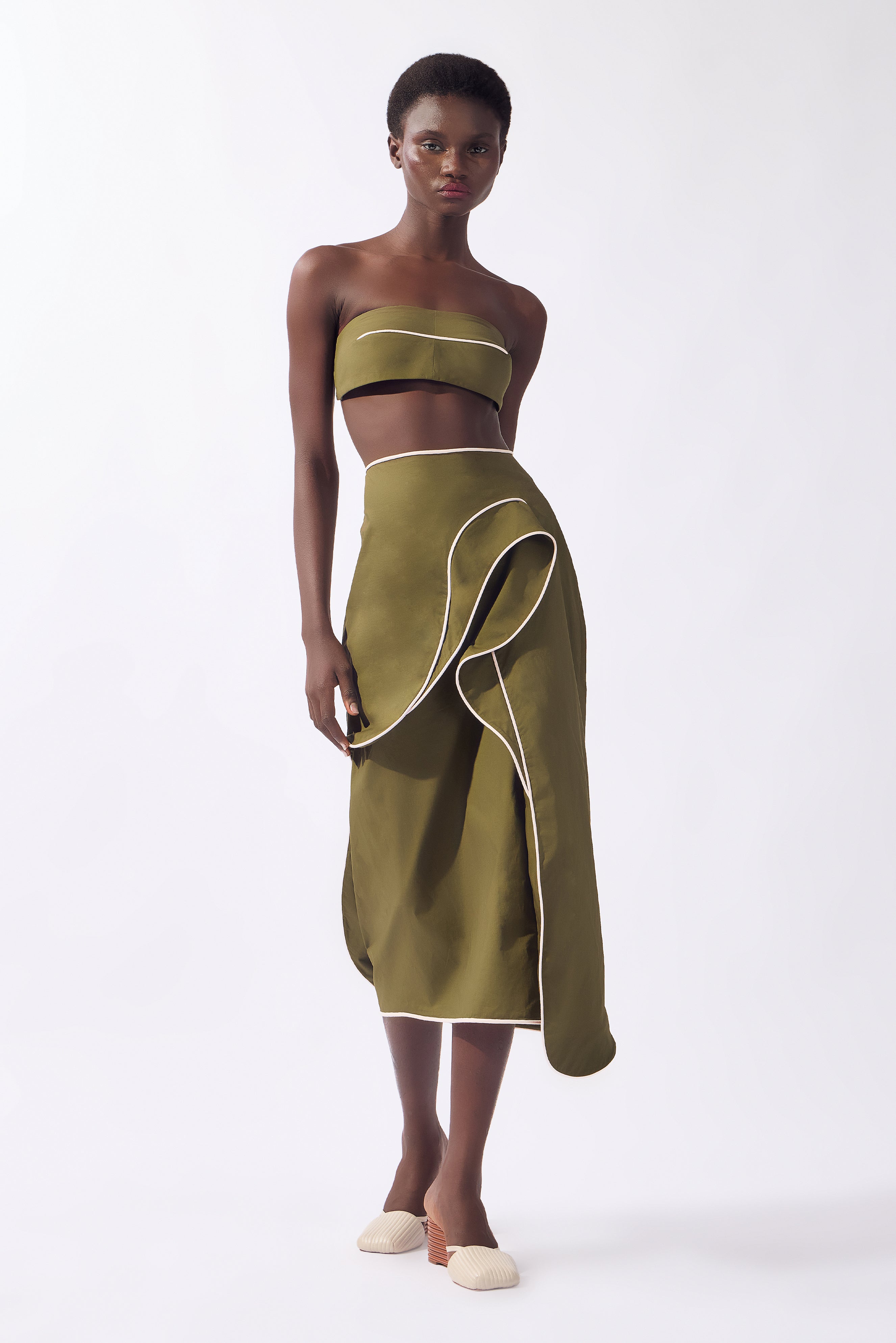 Model wearing the Solid Ruffled Midi Skirt front, color green, made from 98% cotton 2% elastane, styled for a resort look