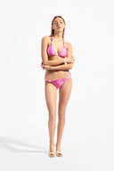 Model wearing the Solid Triangle Bikini color pink with 85% Polyamide 15% Elastane, styled for a beachwear look