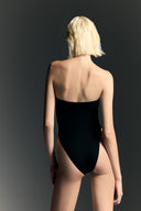 Model wearing the Strapless Cut-Out Swimsuit back from the Adriana Degreas and Sabine Getty collab with 75% Polyamide 25% Elastane styled for a beachwear look. 