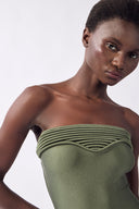 Model wearing the Strapless Swimsuit detail color olive, made from 85% polyester 15% elastane, styled for beachwear look