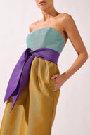 Model wearing the Structured Maxi Dress detail color ochre made with 100% polyetser, styled for an evening look