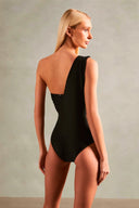 Model wearing the Timeless One Shoulder Swimsuit back color black with 85% POLYAMIDE 15% SPANDEX fabric for a beachwear look