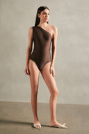 Model wearing the Timeless One Shoulder Swimsuit color coffee with 85% POLYAMIDE 15% SPANDEX fabric for a beachwear look