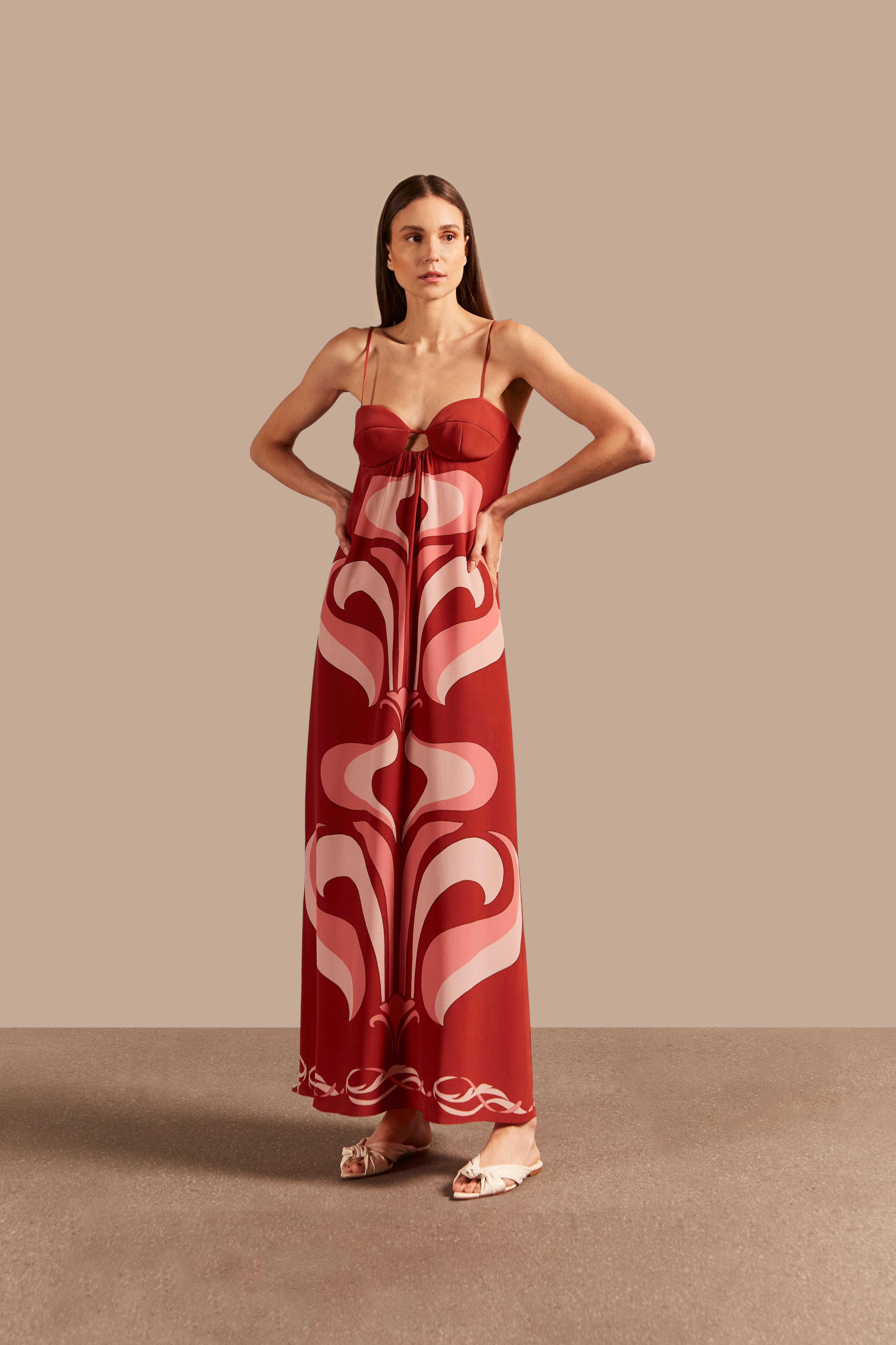 Model wearing the Vintage Lily Dark Red Long Dress With Straps showcasing the front of it's vintage-inspired print, on a silk fabric.