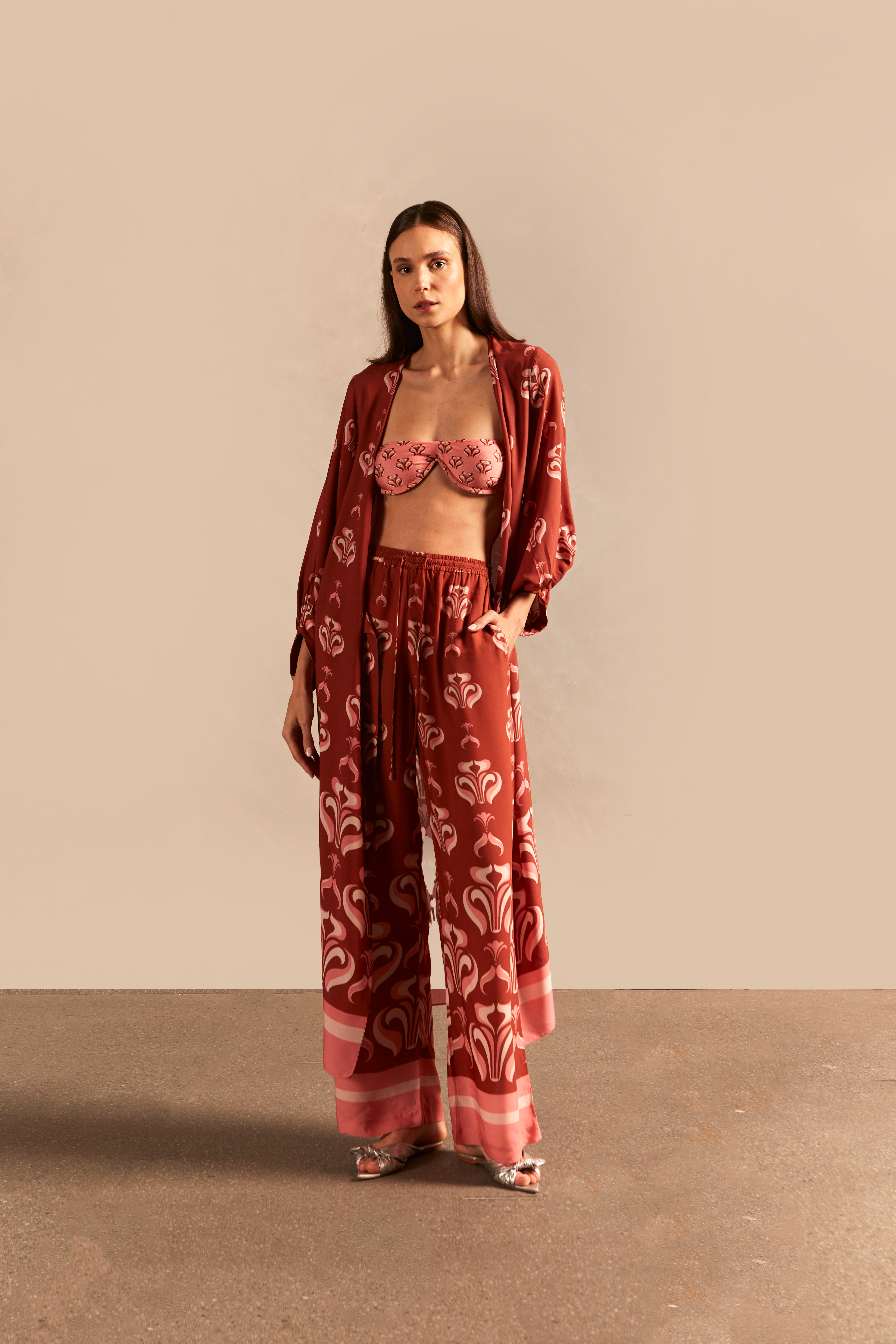 Model wearing the Vintage Lily Long Robe showcasing the front of it's vintage-inspired dark red with pink print, on a viscose fabric.