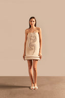 Model wearing the Vintage Lily Solid Beige Appliqué Short Dress showcasing the front of it's exquisite details, on a polyester fabric.