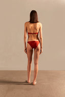 Model wearing the Vintage Lily Solid Red Strapless Bikini showcasing the back of it's structured top, on a stretchy fabric.