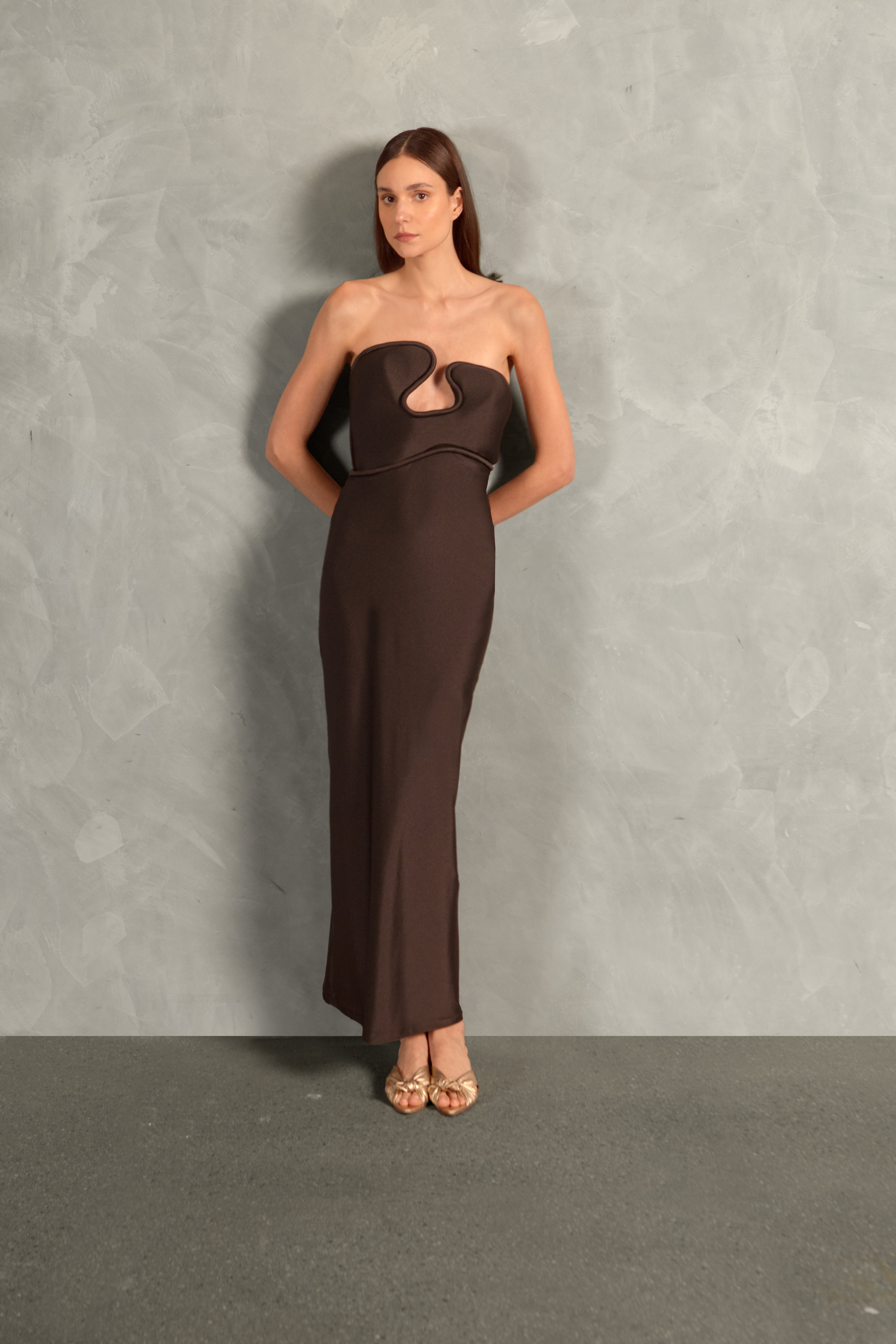 Model wearing the Waves Strapless Long Dress Front showcasing its Coffee color on 85% Polyamide 15% Elastane fabric, styled for a evening look.  