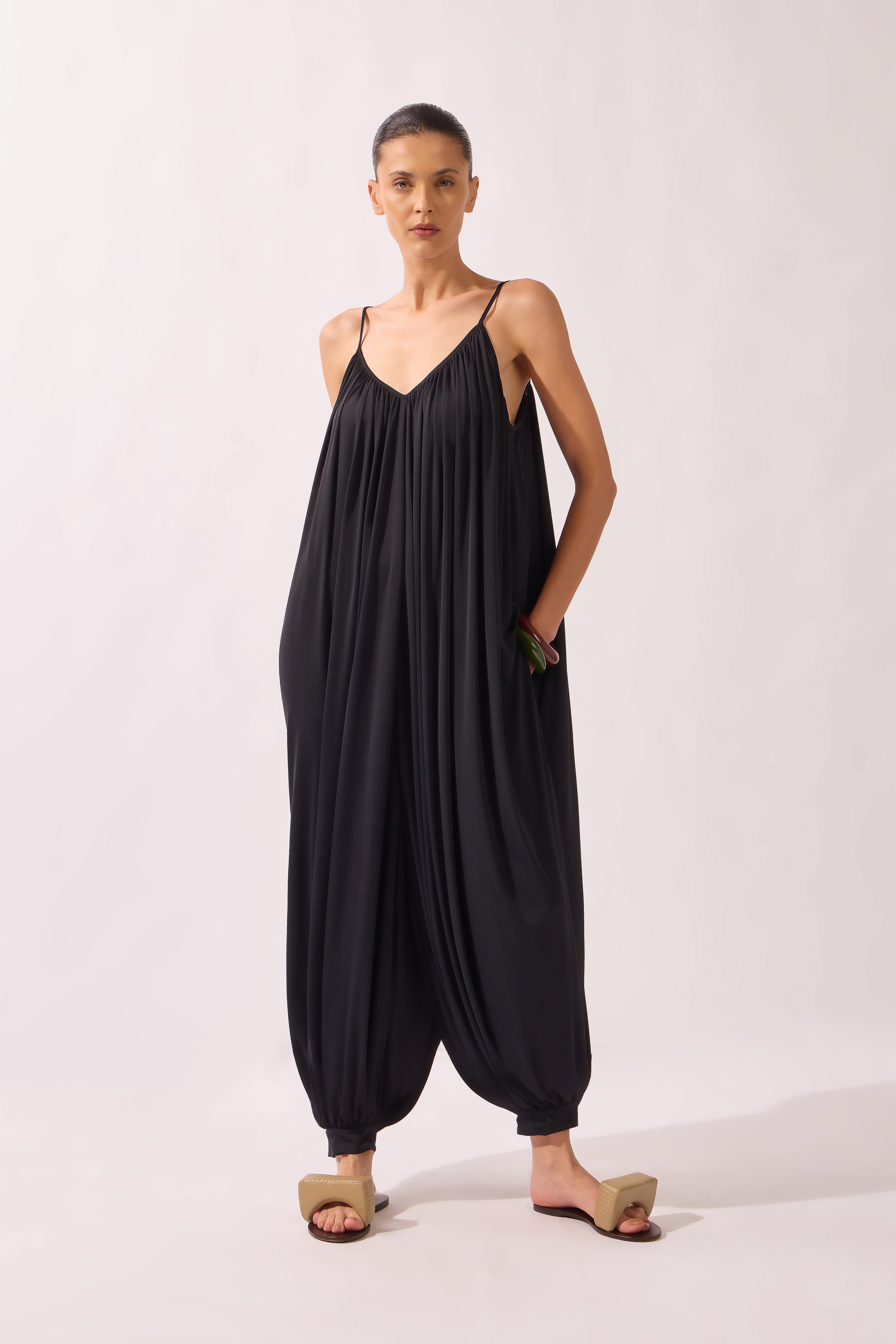 Model wearing the Wide Jersey Jumpsuit front color black, made from 85% polyamide 15% elastane, styled for a beachwear look