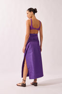 Model wearing the Wrap Maxi Skirt back color purple made with 50% polyetser 40% polyamide 5% elastane, styled for a post-beach look