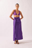 Model wearing the Wrap Maxi Skirt front color purple made with 50% polyetser 40% polyamide 5% elastane, styled for a post-beach look