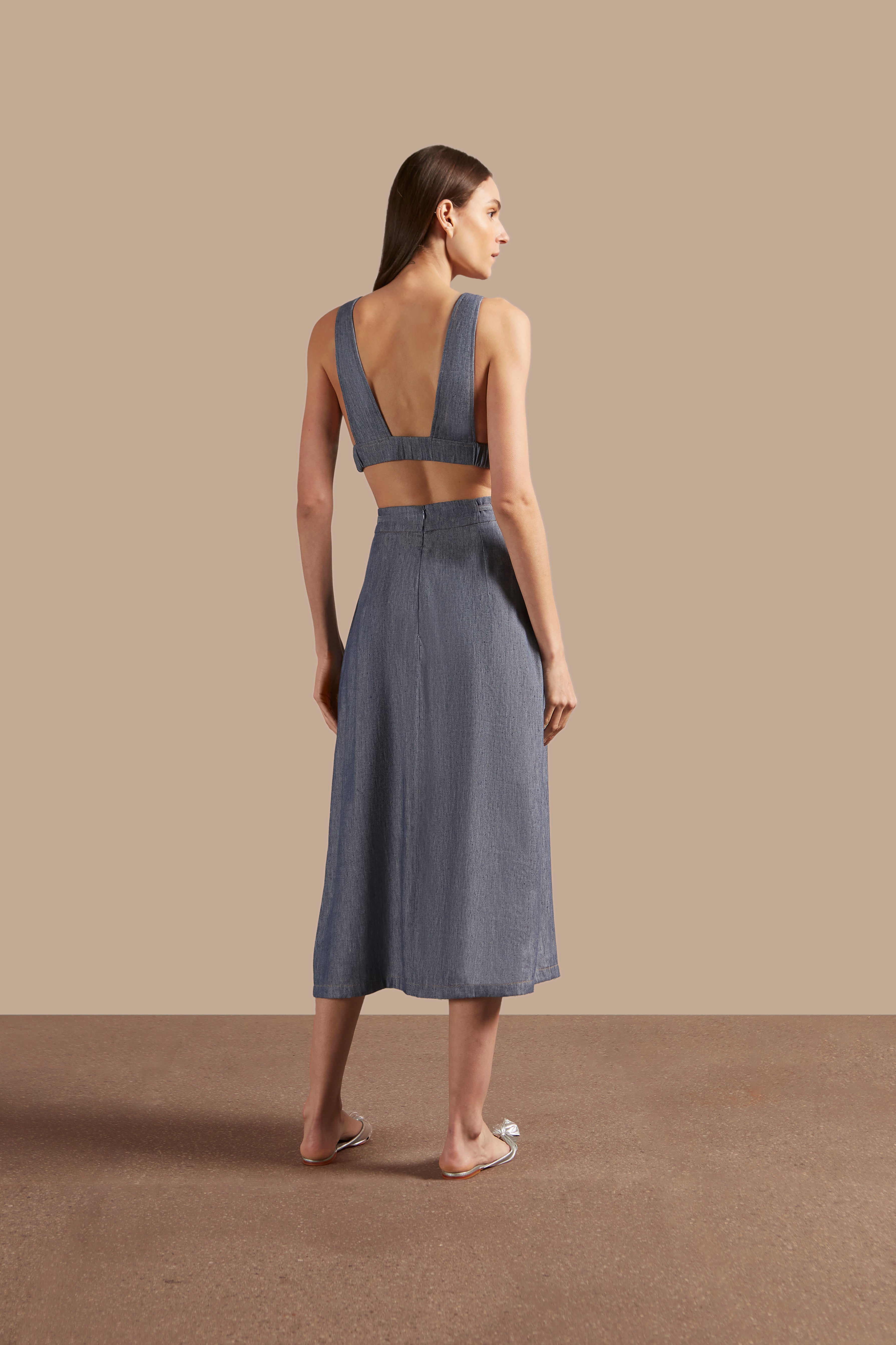 Back view of Adriana Degreas' Jeans Pleated Midi Skirt in blue, showcasing the flowy pleated fabric and midi length.