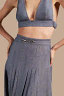 Close-up view of Adriana Degreas' Jeans Pleated Midi Skirt, highlighting the high-waist design and pleated details in a denim-inspired blue fabric.