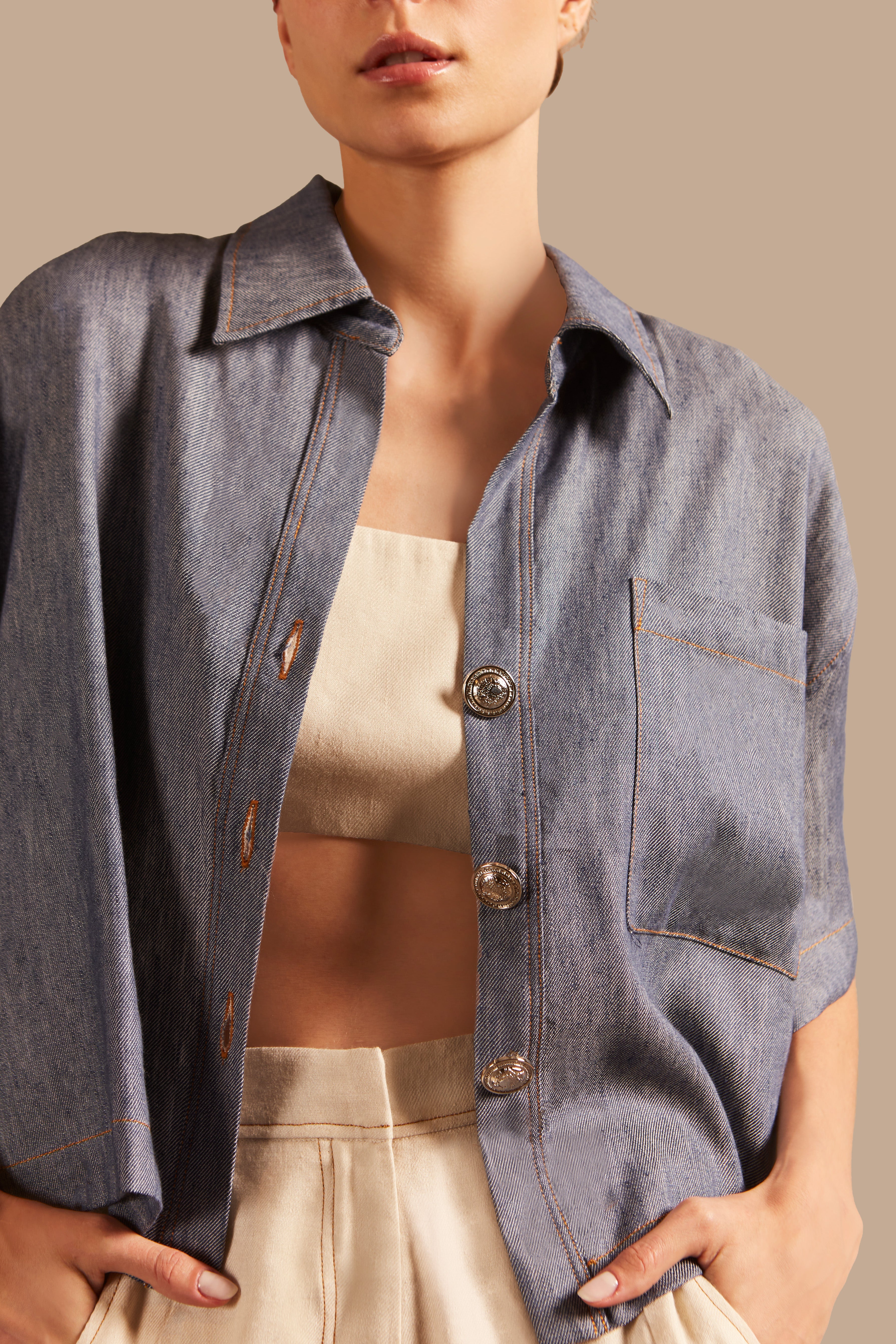 Close-up view of Adriana Degreas' Jeans Short-Sleeved Shirt, highlighting the front pocket and button details in a denim-inspired blue fabric.