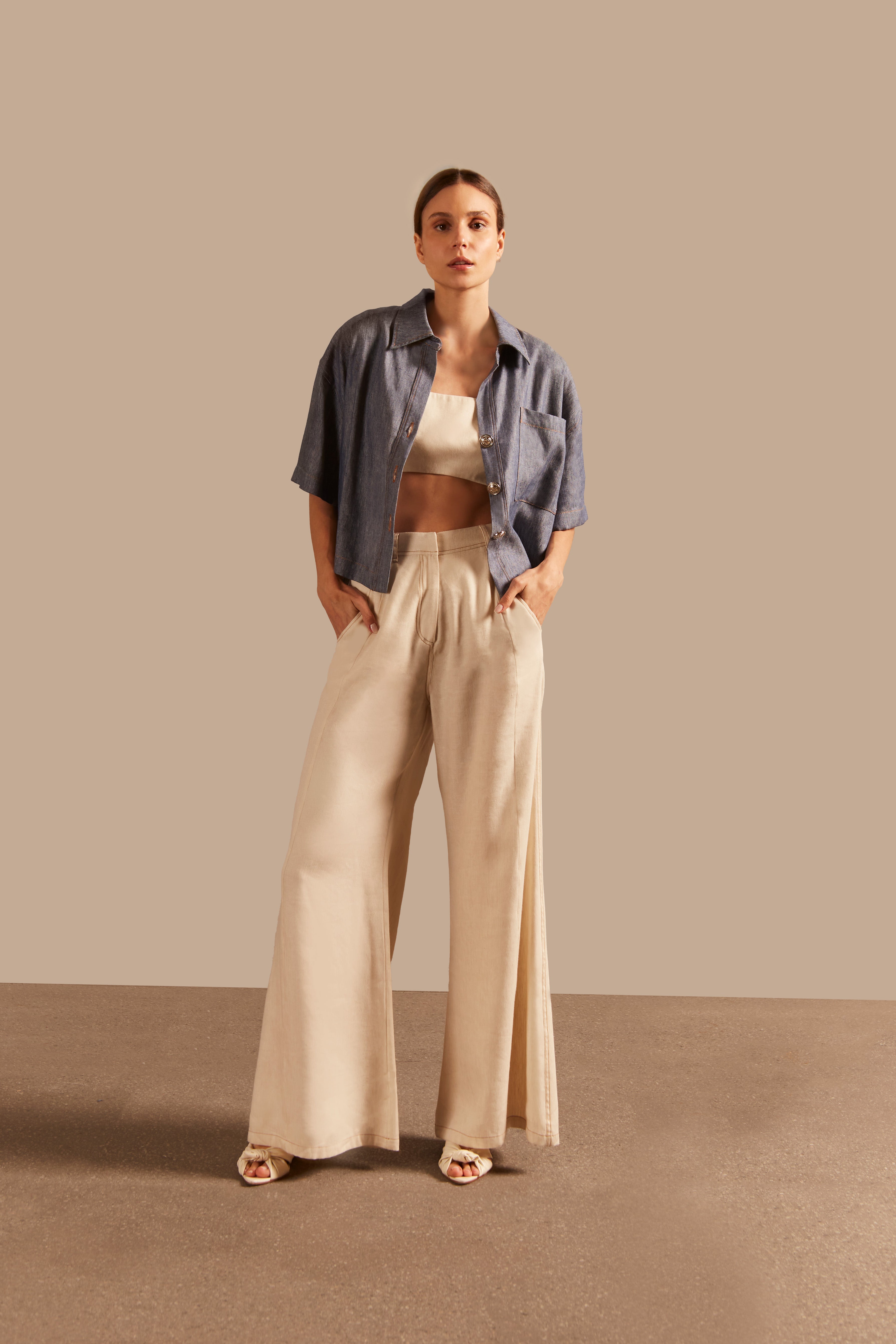 Styled front view of Adriana Degreas' Jeans Short-Sleeved Shirt, paired with cream trousers for a chic and effortless summer look.