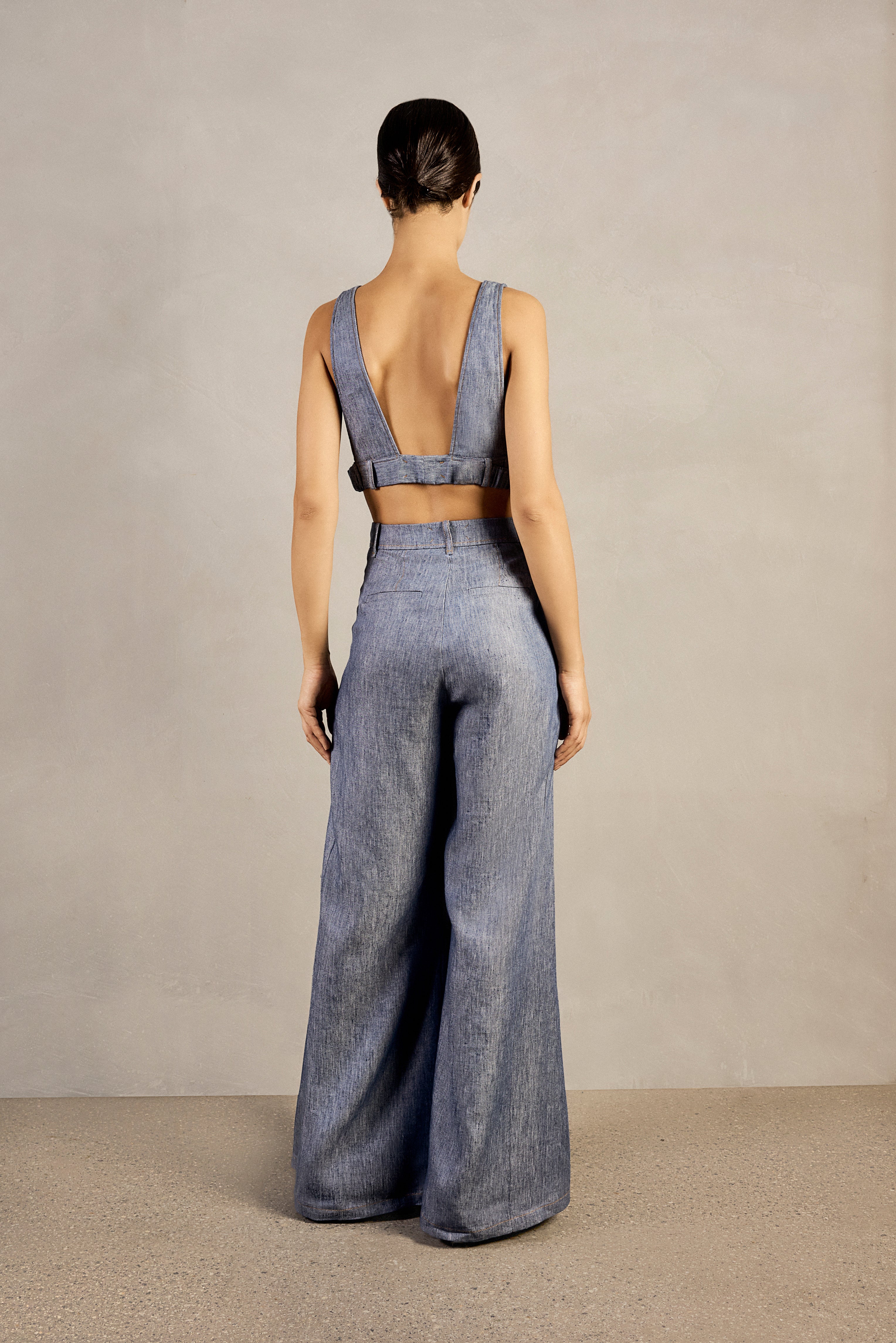 Adriana Degreas' Jeans V-Neck Top styled with matching wide-leg pants in denim-inspired blue, showcasing a relaxed and urban look.
