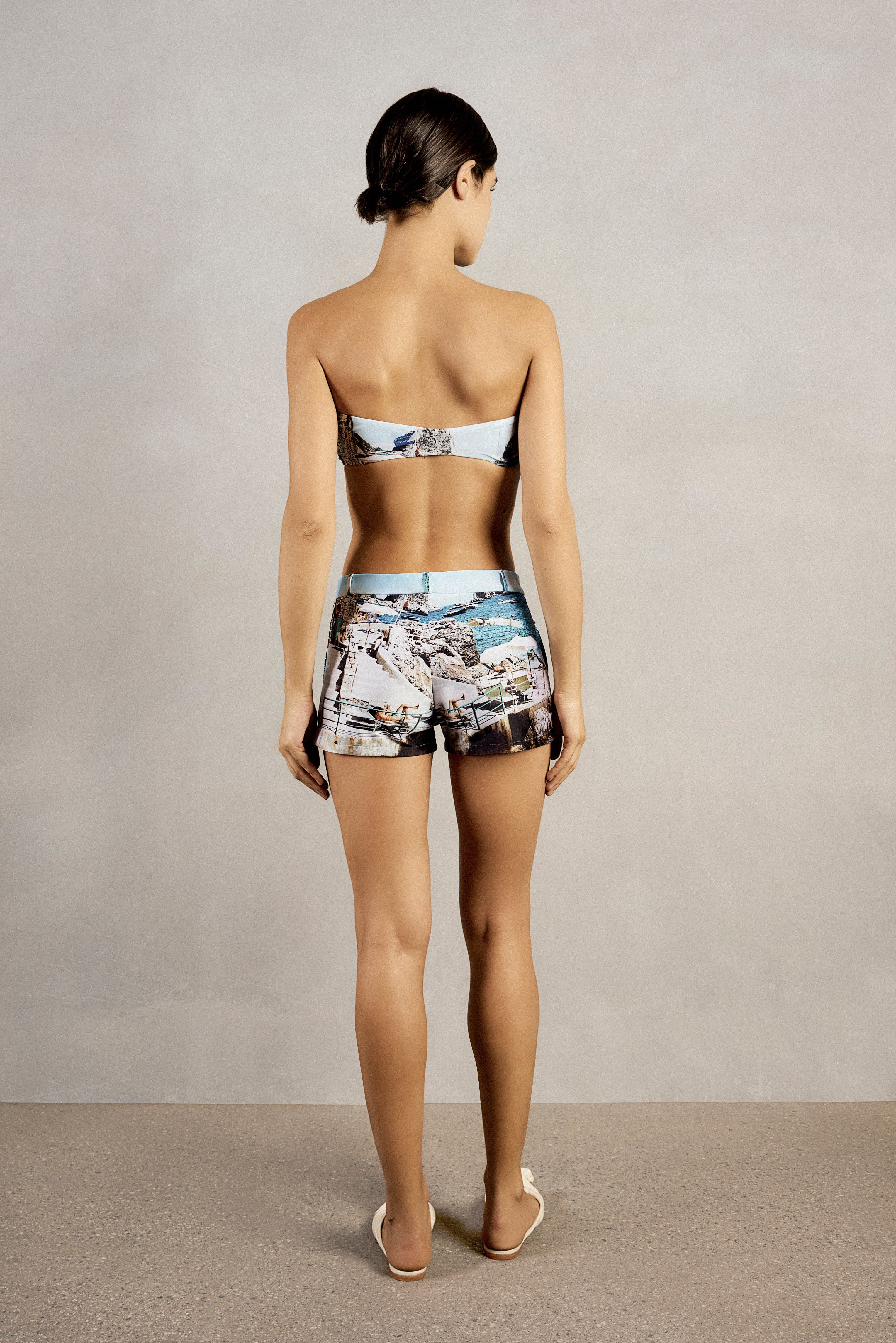 Back view of Adriana Degreas' Postcard Genderless Shorts, showcasing a low-waist design and vibrant postcard print.